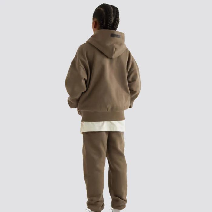 The Fear of God Essentials Kids Tracksuit in camel is a stylish and comfortable tracksuit set for children. It is made by Fear of God, a luxury fashion brand known for its street-inspired and casual designs. The tracksuit is made of a comfortable and durable fabric, and comes in a camel color. The set includes a full-zip hoodie and pants with ribbed cuffs and hem for a snug fit. The tracksuit often features the brand's logo on the chest. The camel color gives it a warm and neutral look, perfect for any occasion. It can easily be paired with other neutral colors for a cohesive outfit.