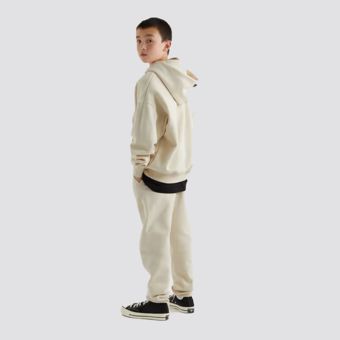 The Fear of God Essentials Kids Tracksuit in cream is a stylish and comfortable tracksuit set for children. It is made by Fear of God, a luxury fashion brand known for its street-inspired and casual designs. The tracksuit is made of a comfortable and durable fabric, and comes in a cream color. The set includes a full-zip hoodie and pants with ribbed cuffs and hem for a snug fit. The tracksuit often features the brand's logo on the chest. The cream color gives it a clean and timeless look, perfect for any occasion.