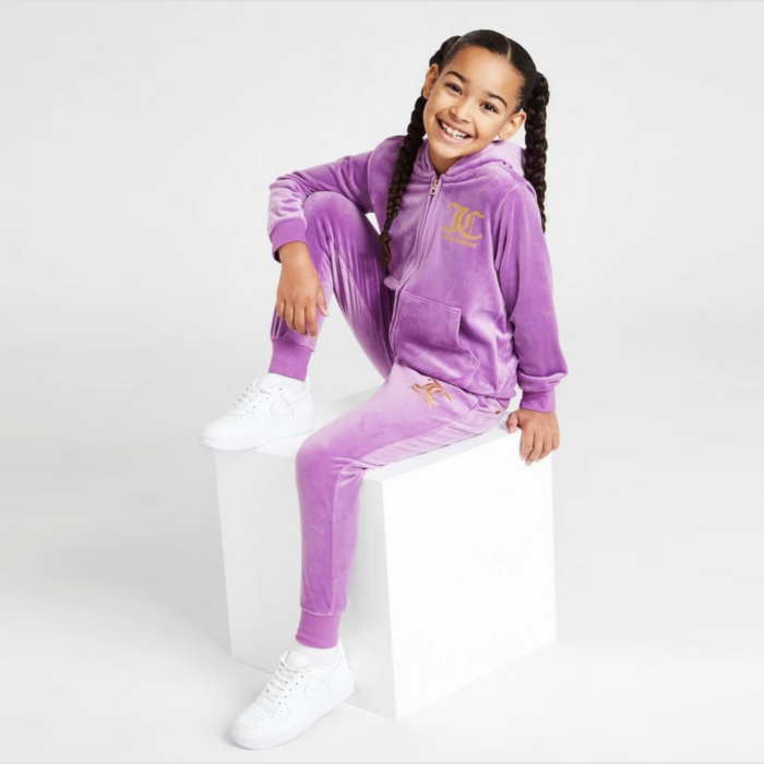 The Juicy Couture Girls' Velour Full Zip Tracksuit in purple is a stylish and comfortable tracksuit for girls. It is made of a soft velour fabric that is both warm and stretchy. The tracksuit features a full zip front, ribbed cuffs and waistband, and two front pockets. The Juicy Couture logo is embroidered on the left chest and on the back of the pants. The purple color gives it a unique and attractive look. The set includes both top and bottom. Juicy Couture is known for their high-end tracksuits and this one is no exception, it is likely to be a bit more expensive than other kids tracksuits.