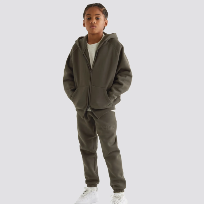 The Fear of God Essentials Kids Tracksuit in camel is a stylish and comfortable tracksuit set for children. It is made by Fear of God, a luxury fashion brand known for its street-inspired and casual designs. The tracksuit is made of a comfortable and durable fabric, and comes in a camel color. The set includes a full-zip hoodie and pants with ribbed cuffs and hem for a snug fit. The tracksuit often features the brand's logo on the chest. The camel color gives it a warm and neutral look, perfect for any occasion. It can easily be paired with other neutral colors for a cohesive outfit.