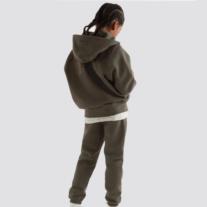 The Fear of God Essentials Kids Tracksuit Zip-up Hoodie is a stylish and comfortable hoodie for children, part of a tracksuit set. It is made by Fear of God, a luxury fashion brand known for its street-inspired and casual designs. The hoodie features a full-zip front design, a hood with drawstring, and ribbed cuffs and hem for a snug fit. The hoodie is usually made of soft and comfortable cotton material and comes in a variety of colors. It's perfect for everyday wear and can be paired with the matching track pants to complete the tracksuit look.